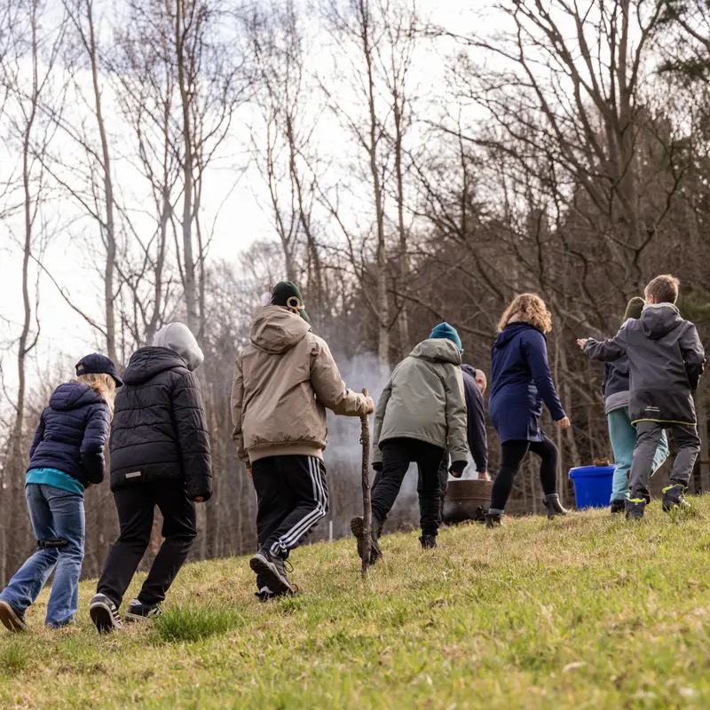 Mehrere Personen gehen auf einen Hügel hinauf.