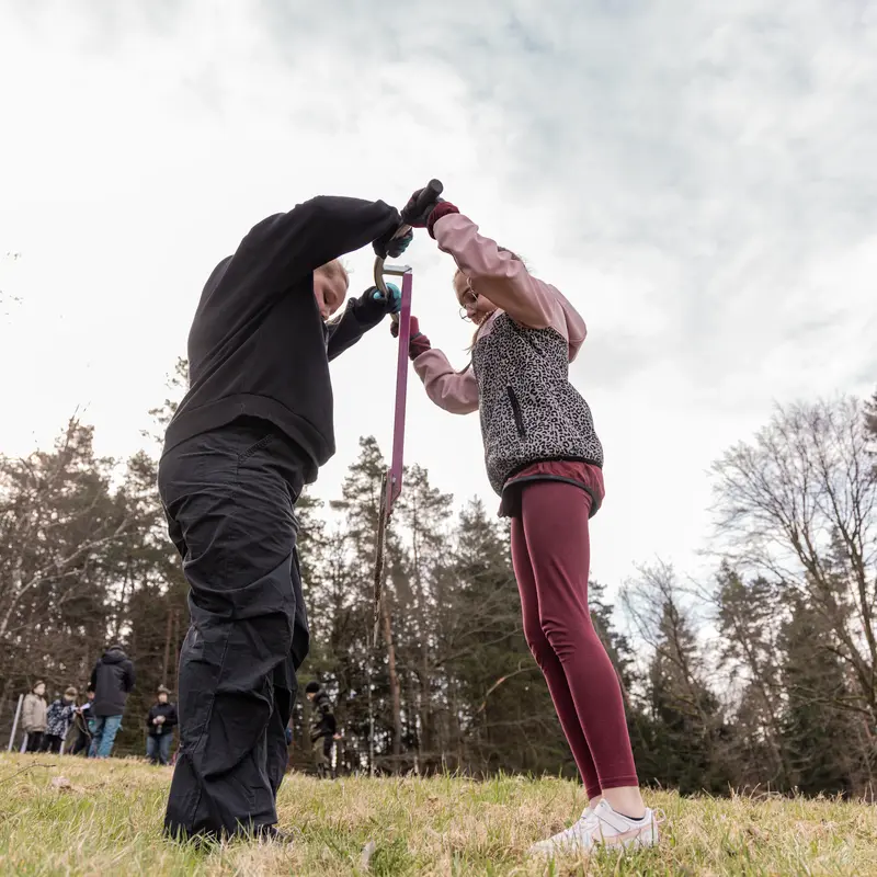 Zwei Kinder stechen ein Pflanzloch in die Erde.